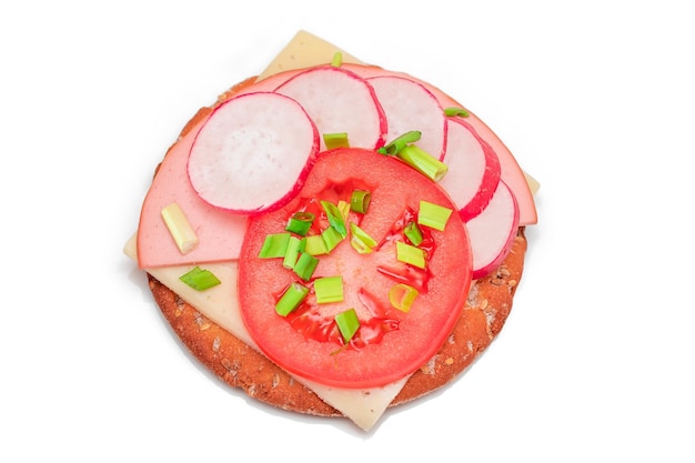 Chrupiąca kanapka z krakersami z kiełbasą pomidorową, serem, cebulą i rzodkiewką na białym tle