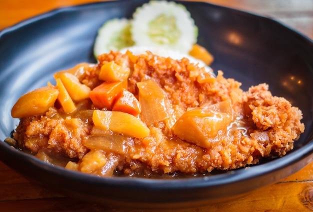 Zdjęcie chrupiący smażony kotlet wieprzowy z curry i ryżem.