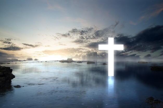 Chrześcijański krzyż na jeziorze i dramatyczne tło nieba