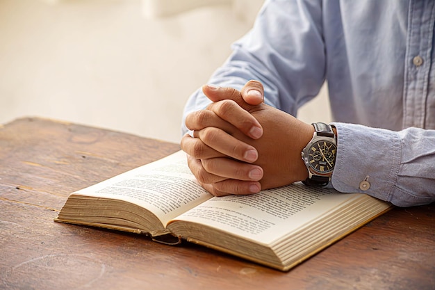 Chrześcijański mężczyzna modli się do Boga z Biblią