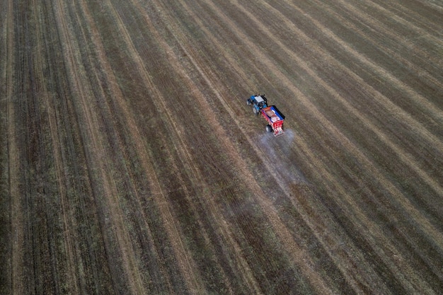 Ciągnik jeździ po polu i produkuje nawozy nieorganiczne