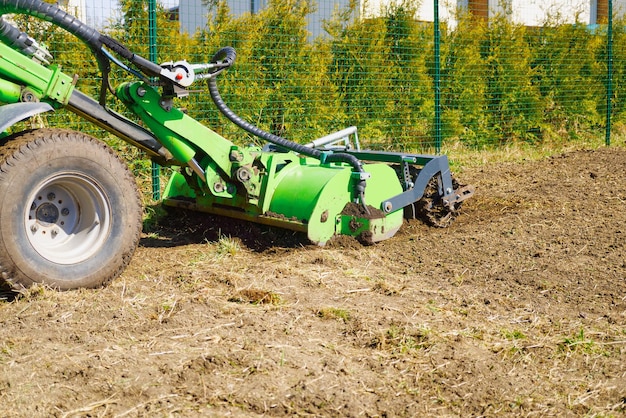 Ciągnik pielęgnuje glebę na polu rolniczym, uwalniając ziemię przemiałową ze starych upraw