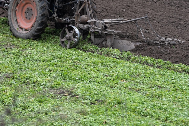 ciągnik rolniczy z pługiem orze pole i przygotowuje się do siewu.