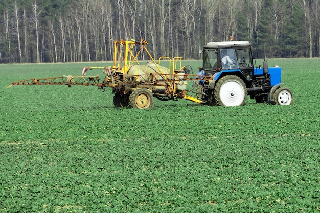 Ciągnik z przyczepą pracuje w polu z pistoletem natryskowym Zastosowanie zaawansowanych technologii w rolnictwie Ekologiczne rolnictwo bez pestycydów