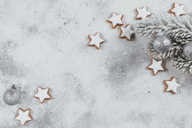 Ciasteczka w kształcie gwiazdy i ozdoby świąteczne na białym tle. Koncepcja ferii zimowych. Widok z góry, wolne miejsce na tekst