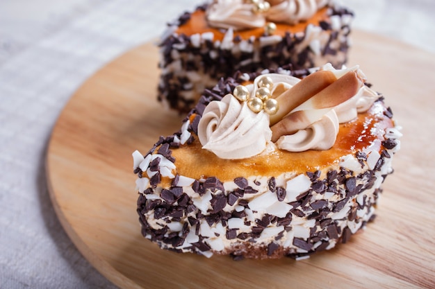 Ciastka z kawałkami czekolady i kremowymi dekoracjami na drewnie
