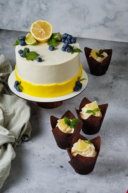 Ciasto cytrynowe przyozdobione cytryną, limonką i świeżymi jagodami. Spersonalizowany deser na urodziny.