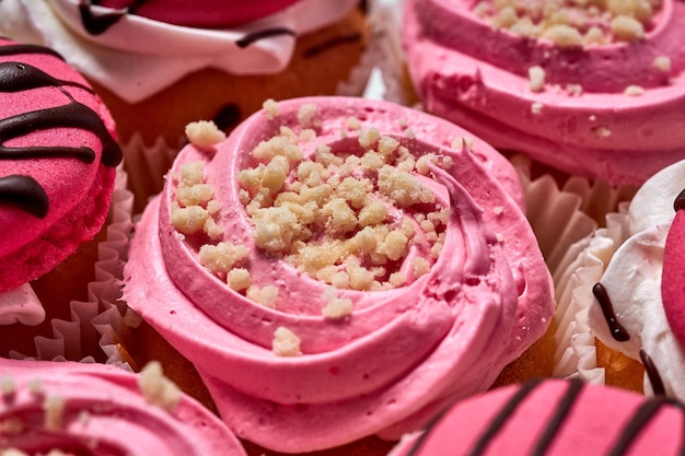 Ciasto deserowe, pyszne babeczki z różowym kremem. Słodki poczęstunek. Zestaw ciast na białym tle