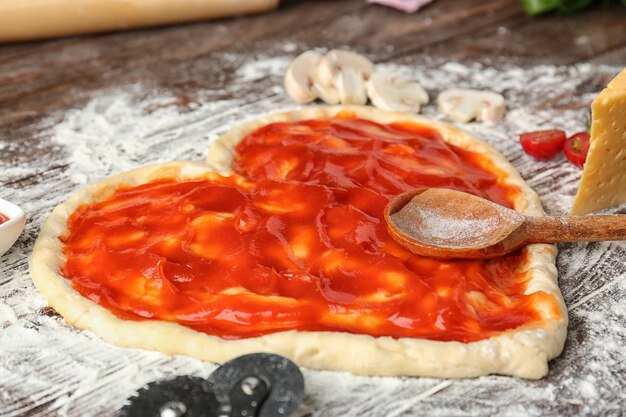 Ciasto Do Pizzy W Kształcie Serca Pokryte Sosem Pomidorowym Na Stole