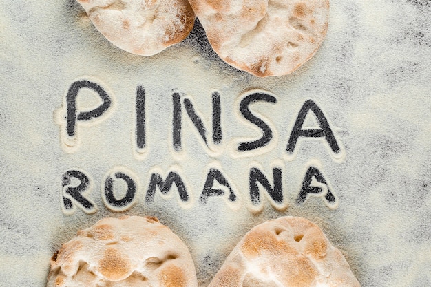 Ciasto i mąka z tekstem pinsa romana na czarnym tle. Scrocchiarella dla smakoszy kuchni włoskiej. Tradycyjne danie we Włoszech.