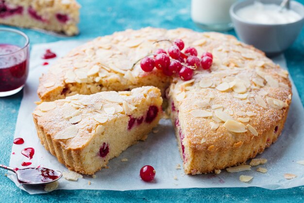 Zdjęcie ciasto migdałowo-jagodowe tarta bakewell tradycyjne brytyjskie ciasto niebieskie tło