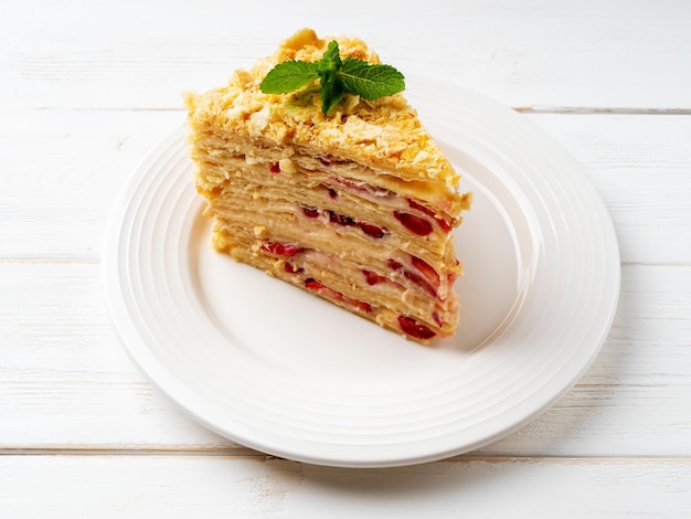 Ciasto napoleońskie w plasterkach z truskawkami ozdobione miętą Ciasto wielowarstwowe z kremem do ciasta