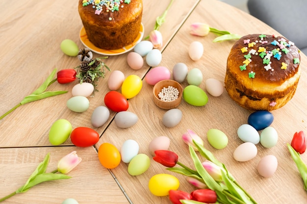 Ciasto wielkanocne i kolorowe jajka na świątecznym stole wielkanocnym.
