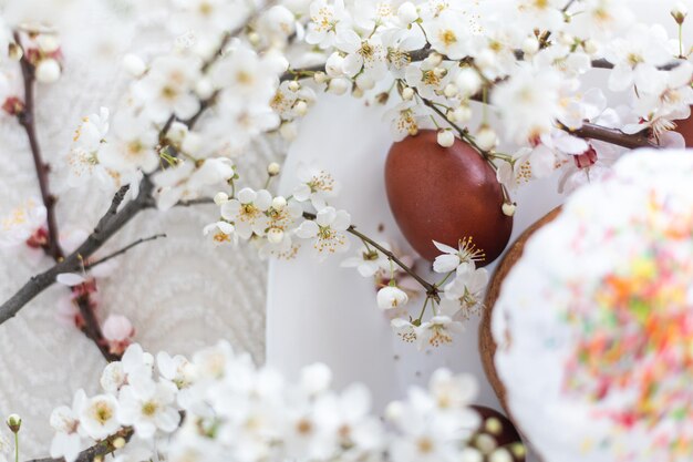 Ciasto wielkanocne i malowane jajka. Kwitnący bukiet leżący na stole w pobliżu.