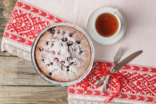 Ciasto wiśniowe Clafoutis na rustykalnym drewnianym stole