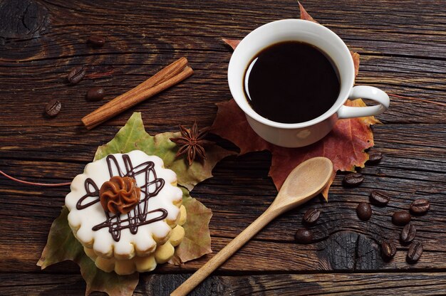 Ciasto Z Kremem Czekoladowym, Filiżanką Kawy I Jesiennymi Liśćmi Na Starym Drewnianym Tle