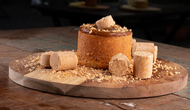 Ciasto z kremem dulce de leche z pacoca i orzeszkami ziemnymi na desce pod rustykalnym stołem z przodu