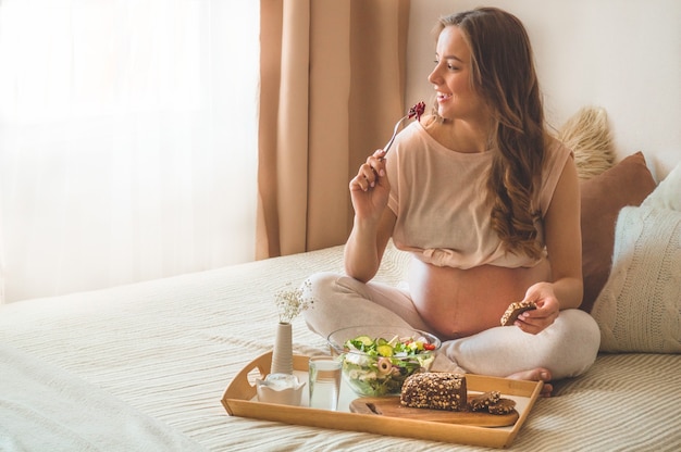 Ciąża I Zdrowe Odżywianie Organiczne. Kobieta W Ciąży, Ciesząc Się Sałatką Ze świeżych Warzyw W łóżku, Wolne Miejsce