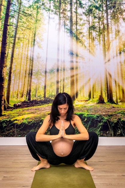 Zdjęcie ciąży brunetka dziewczyna robi joga stwarza koncepcja jogi w ciąży