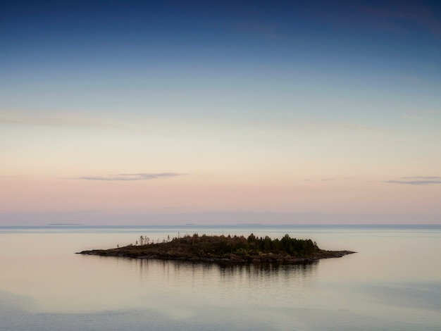 Cichy zachód słońca nad małą wyspą. Jezioro Ładoga. Republika Karelii, Rosja