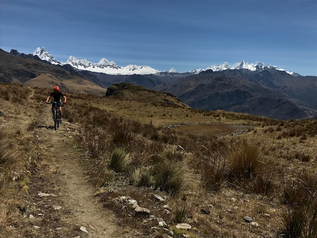 Ciclista acercandose cuesta arriba por un camino estrecho