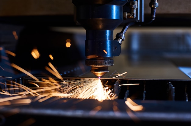Cięcie laserowe CNC metalu z bliska, nowoczesna technologia przemysłowa. Mała głębia ostrości
