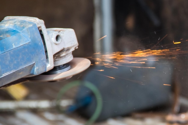 Zdjęcie cięcie metalu za pomocą szlifierki kątowej z bliska