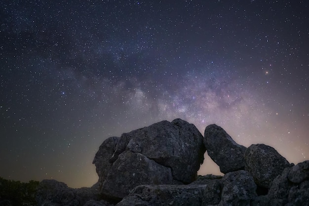 Zdjęcie cielo estrellado con via lactea y rocas con forma de arco natural