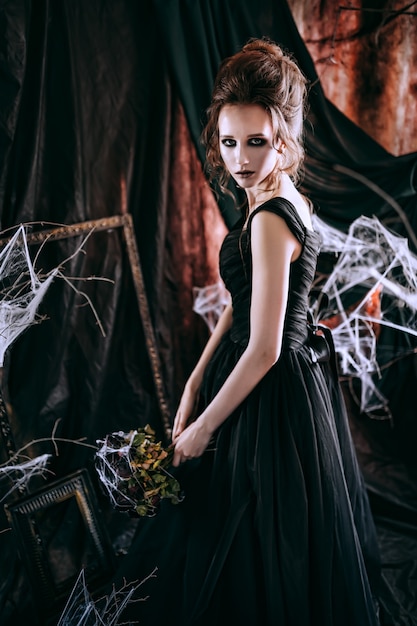 Zdjęcie ciemna piękna kobieta w czarnej sukni. koncepcja halloween