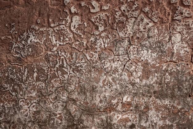 Ciemnobrązowa zrujnowana ściana gipsowa z abstrakcyjną teksturą pęknięcia