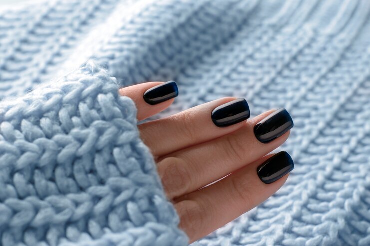 Ciemnoniebieski zimowy lakier żelowy do manicure na zbliżeniu paznokci.