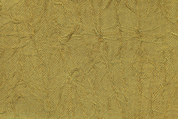 Ciemnożółty falisty materiał tekstylny. Tkanina z fałd tekstury zbliżenie.