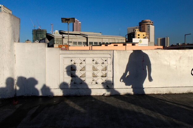 Zdjęcie cień ludzi na budynku na tle niebieskiego nieba