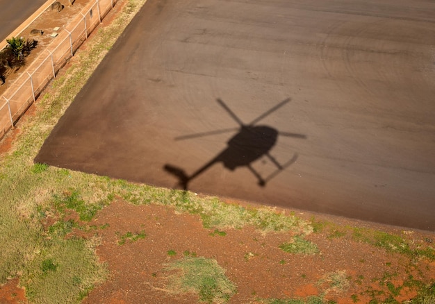 Cień małego helikoptera Hughes lądującego w Lihue w Kauai