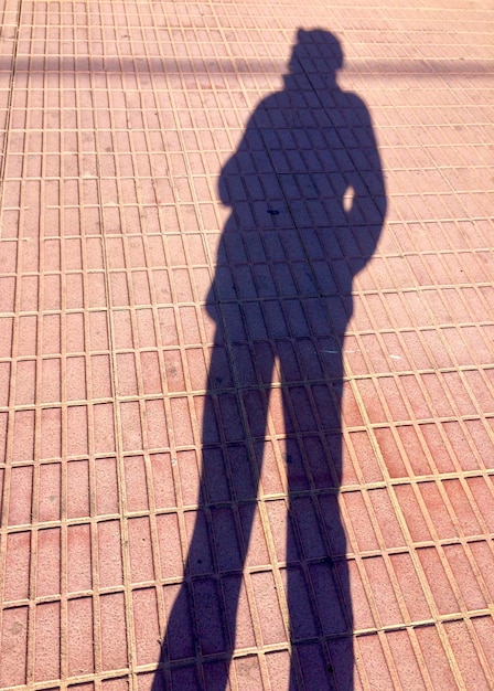 Zdjęcie cień osoby stojącej na chodniku