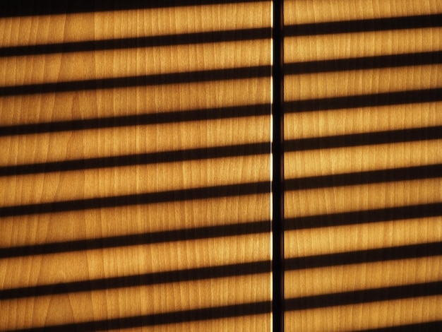 Zdjęcie cień żaluzji na tle drewnianej ściany