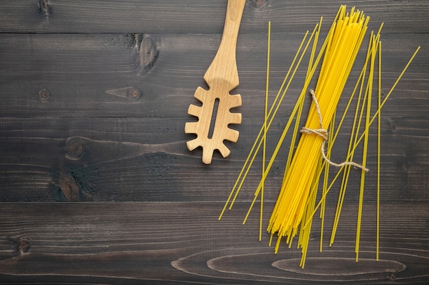 Zdjęcie cienki spaghetti na czarnym drewnianym tle.