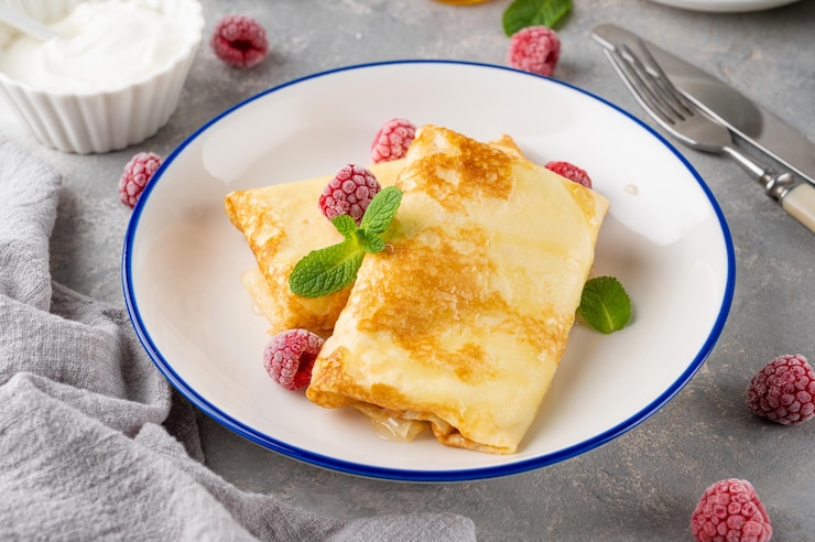 Zdjęcie cienkie naleśniki lub naleśniki z twarogiem miodem kwaśną śmietaną i malinami food for maslenitsa