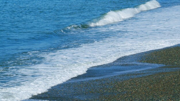 Ciepła woda morska pusta plaża fale uderzające w brzeg fale morskie surfują na plaży w wolnym tempie