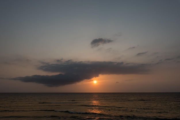 Zdjęcie ciepły wschód słońca z ciemnym chmurem na morzu czerwonym