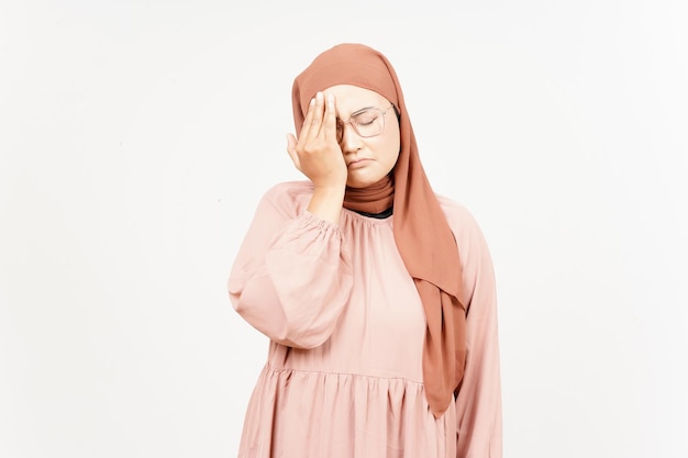 Cierpiący ból głowy pięknej azjatyckiej kobiety noszącej hidżab na białym tle