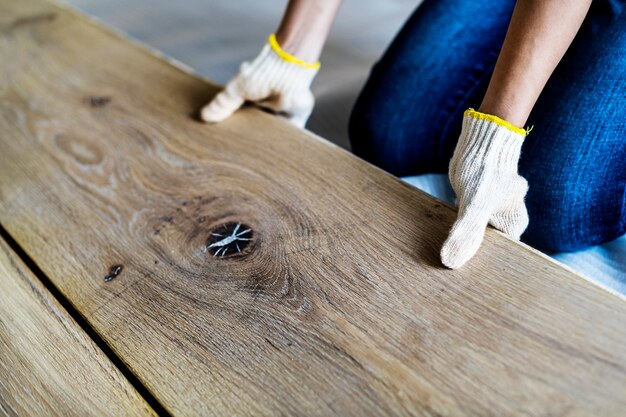 Cieśla mężczyzna instaluje drewnianą podłoga