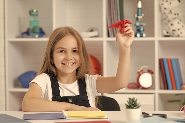 Cieszę się, że dziecko bawi się papierowym samolotem w szkolnej klasie