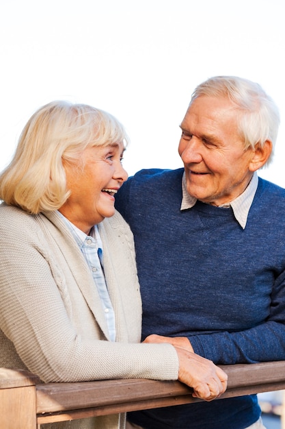 Cieszyć się życiem razem. Szczęśliwa para starszych patrzących na siebie i uśmiechających się, stojąc na zewnątrz