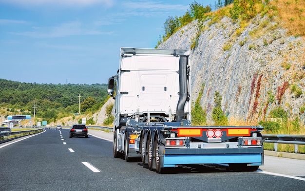 Ciężarówka bez skrzyni na przyczepę na autostradzie asfaltowej w Polsce. Transporter ciężarowy