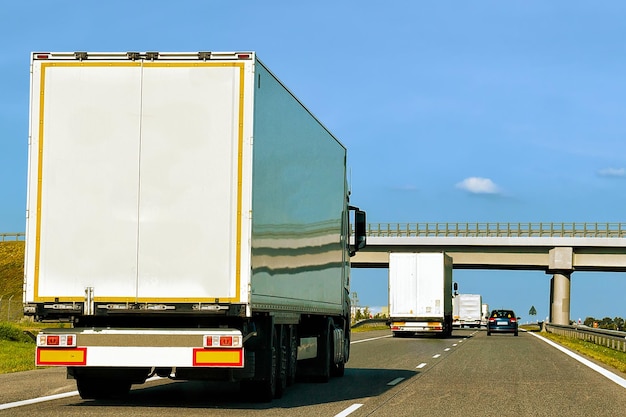 Ciężarówka w letniej drodze Polski. Kierowca ciężarówki na autostradzie. Ciężarówka wykonująca prace logistyczne. Naczepa z kierowcą. Jazda samochodem na duże ładunki. Dostawa ładunku. Branża transportowa eksport. Kontener z towarem