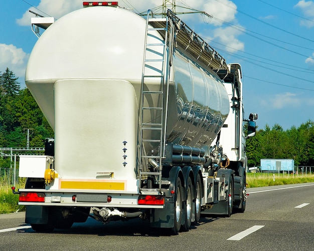 Zdjęcie ciężarówka z magazynem cieczy lub oleju na drodze lub autostradzie w szwajcarii. samochód ciężarowy z cysterną serwisową przy pracach logistycznych. cysterna naczepy. jazda samochodem towarowym. dostawa ładunku. branża transportowa eksport