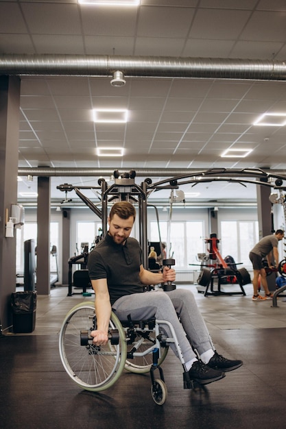 Ciężko pracujący inwalida ćwiczący z ciężarkami na siłowni