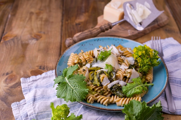 Cime Di Rapa Makaron W Talerzu Dalej Z Parmezanem Na Drewnianym Stole. Tradycyjne Jedzenie Z Południa Włoch, Z Apulii. Zdjęcie W Stylu Rustykalnym.