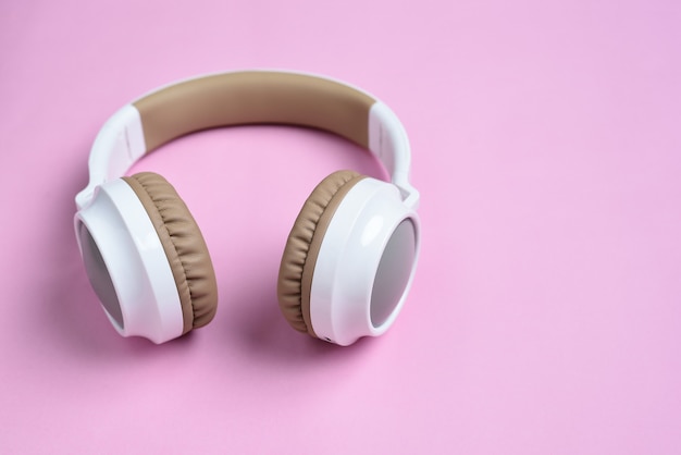 Close-up Cool Bezprzewodowe słuchawki na różowym tle. Koncepcja muzyki